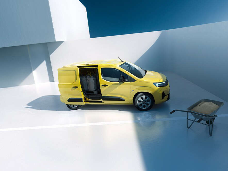 Вигляд збоку на новий Opel Combo Cargo жовтого кольору з відчиненими відсувними дверима з правого боку